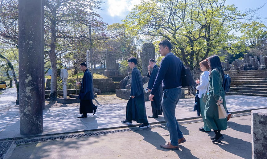 屋外の施設を歩きながら案内を受ける参加者グループの様子