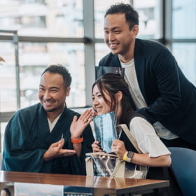 テーブルで笑顔の記念撮影をする3人