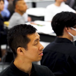 セミナー会場で人々が真剣に話を聞いている様子