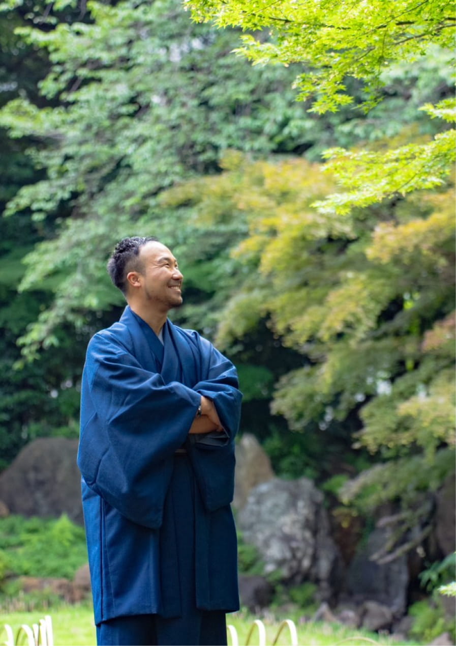 小倉瑞季が和装で自然の中に立ち、上を見上げて微笑む様子