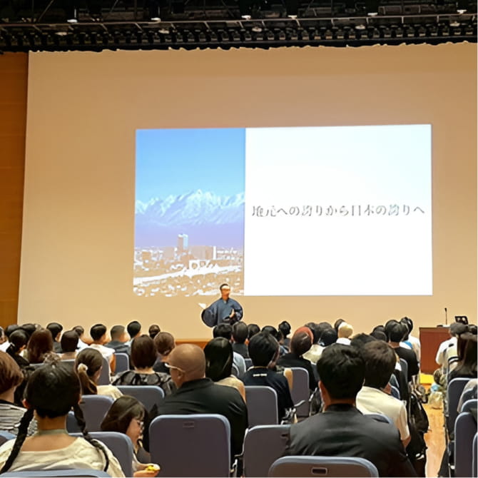 壇上で講演する小倉瑞季と、その話を聞く多くの観客