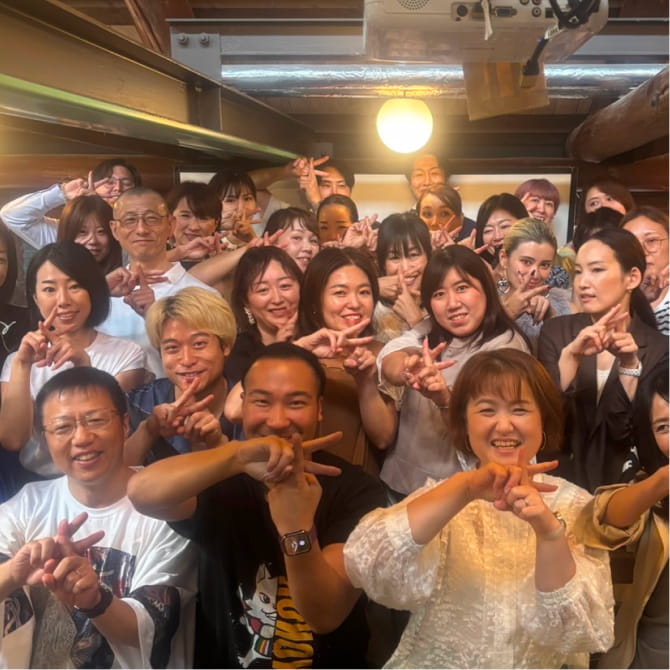 多くの人が室内で笑顔でポーズをとっている集合写真