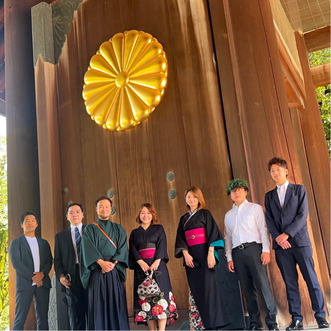 神社の大きな門の前で並んで撮影したグループ写真